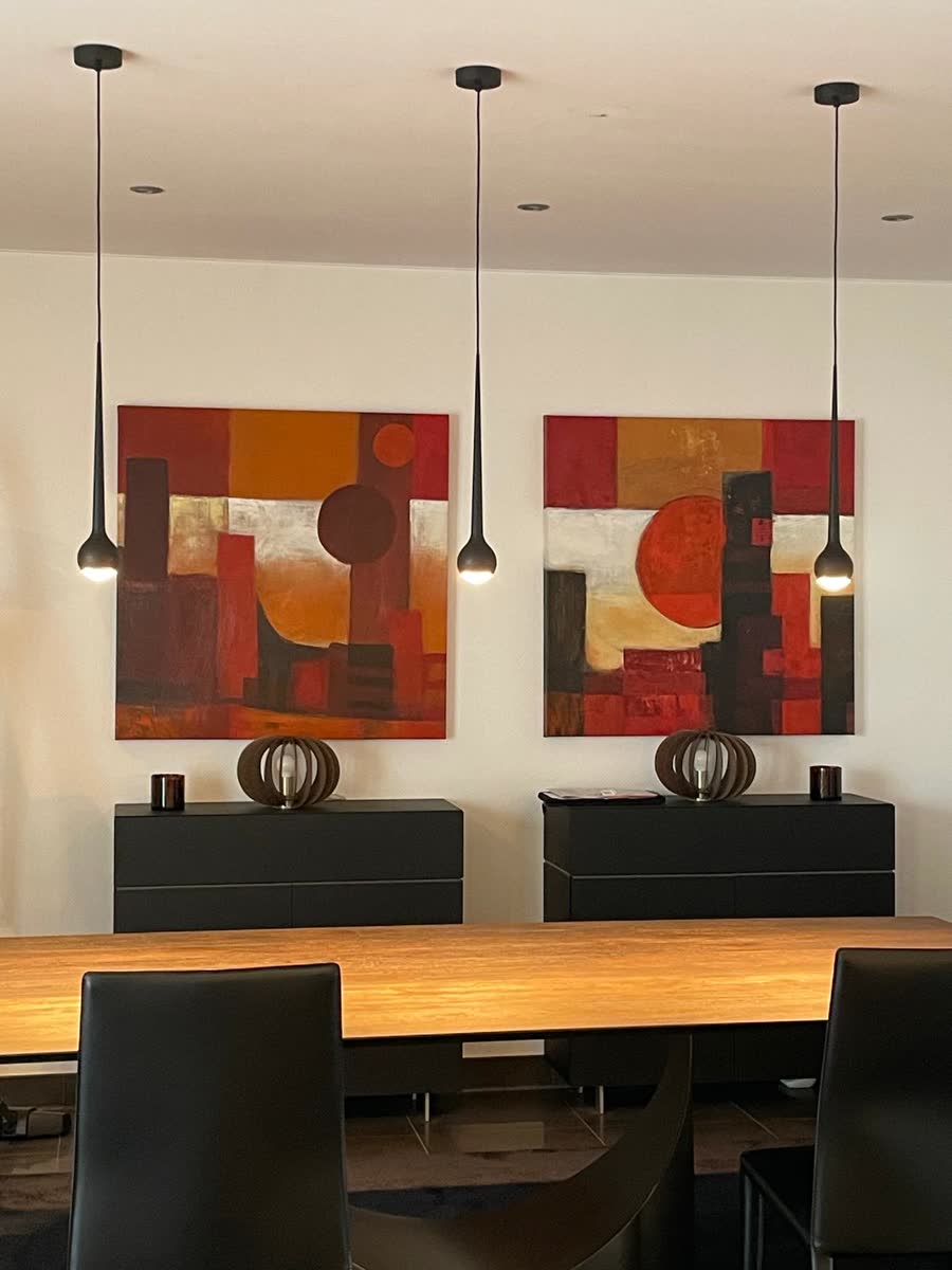 Suspensions design et spots encastrés dans une salle à manger au Luxembourg