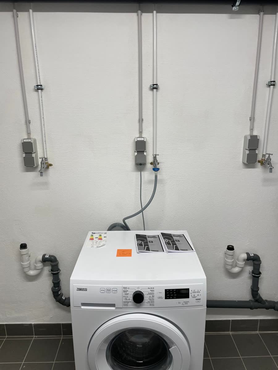 Prises étanches et raccordements machines dans une buanderie collective au Luxembourg